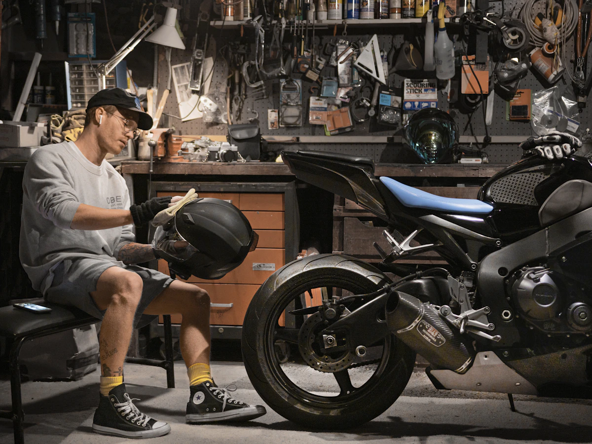 Rider beside a sport motorcycle on an active workshop floor