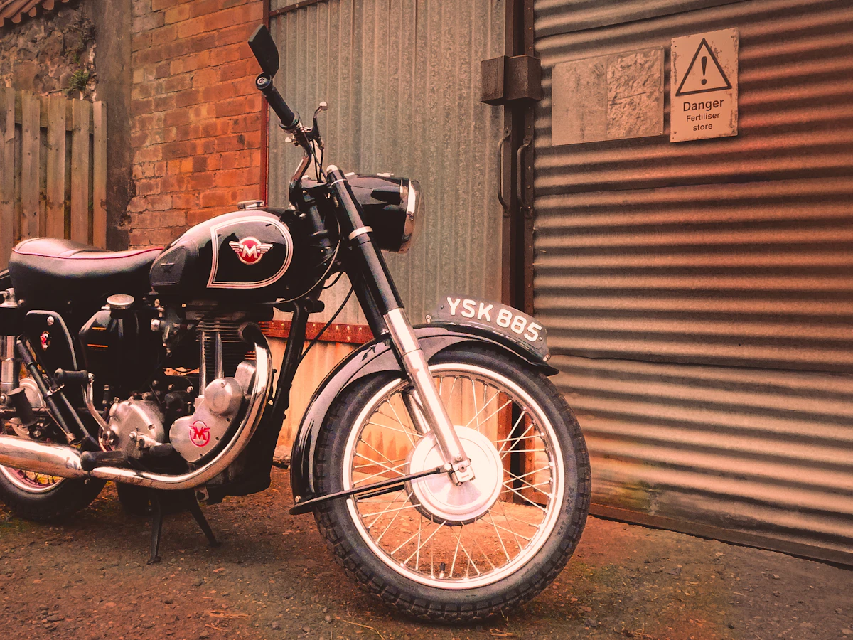 Vintage motorcycle parked outside a corrugated garage