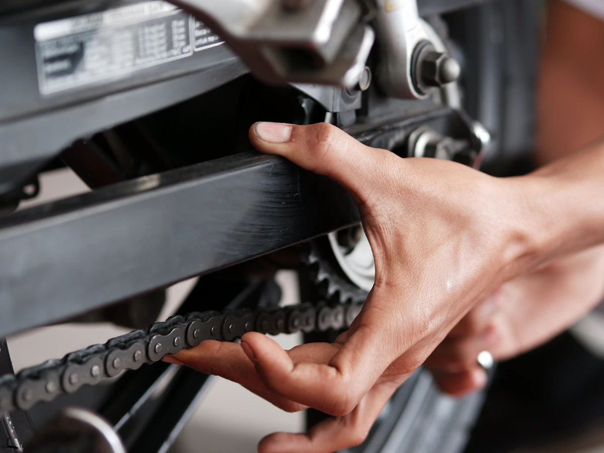 Technician checking motorcycle chassis components by hand