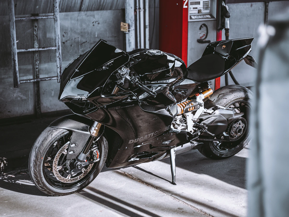 Black performance motorcycle parked inside a service garage