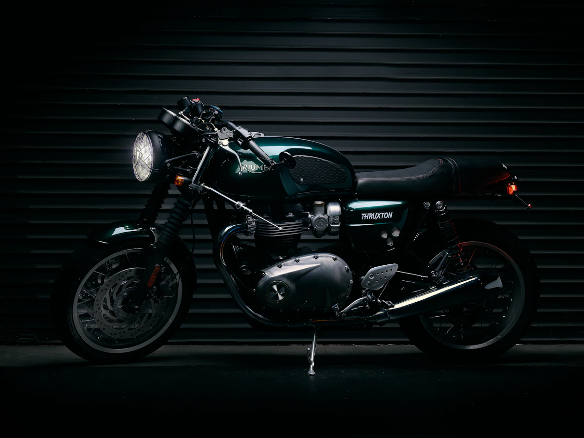 Dark green motorcycle displayed against a workshop shutter